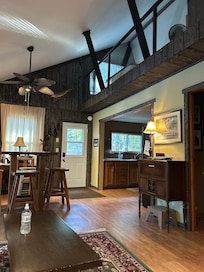 View from the living room showing the kitchen and the loft with the queen bed, top right