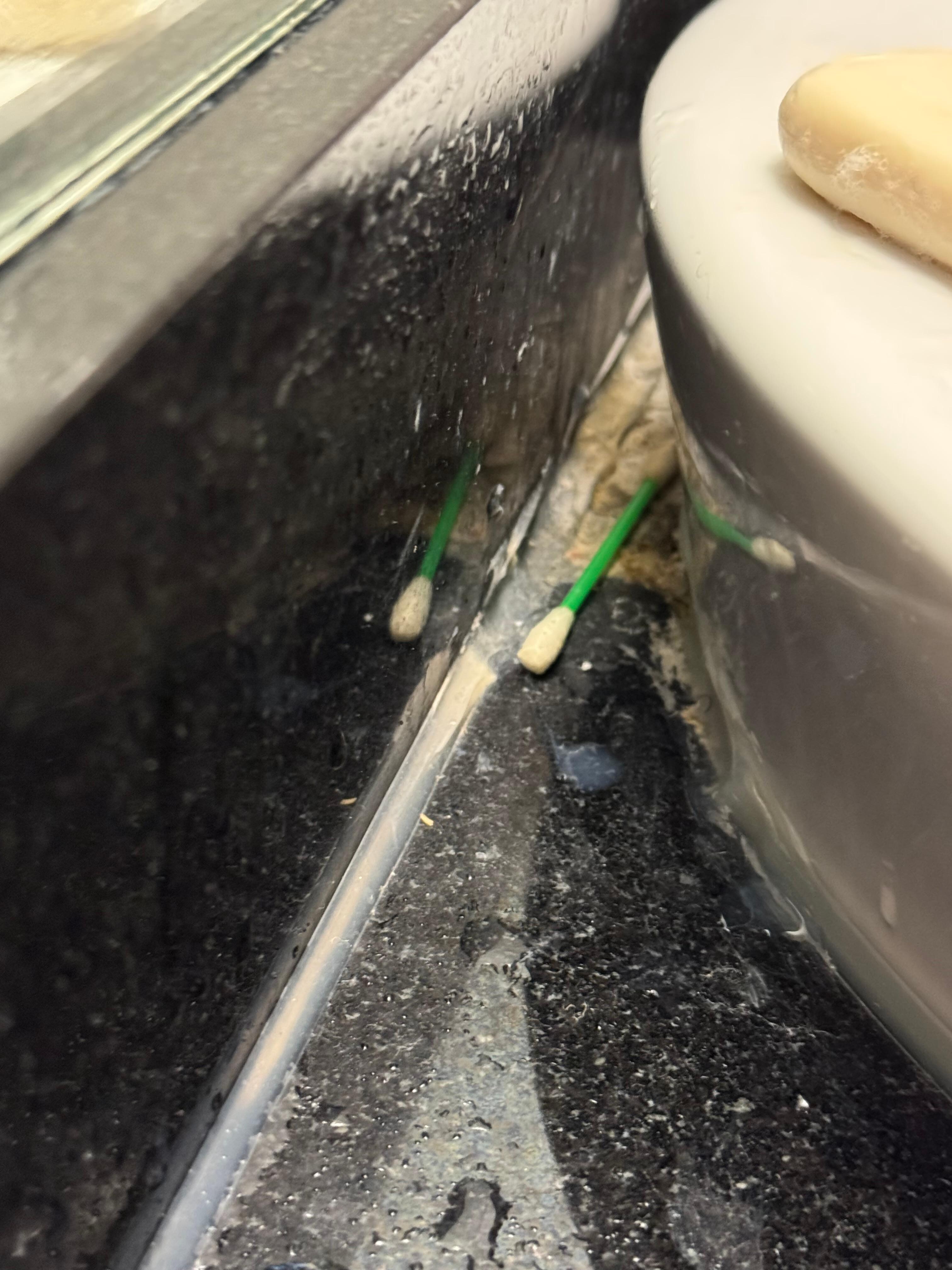 Dirty q-tip behind the sink