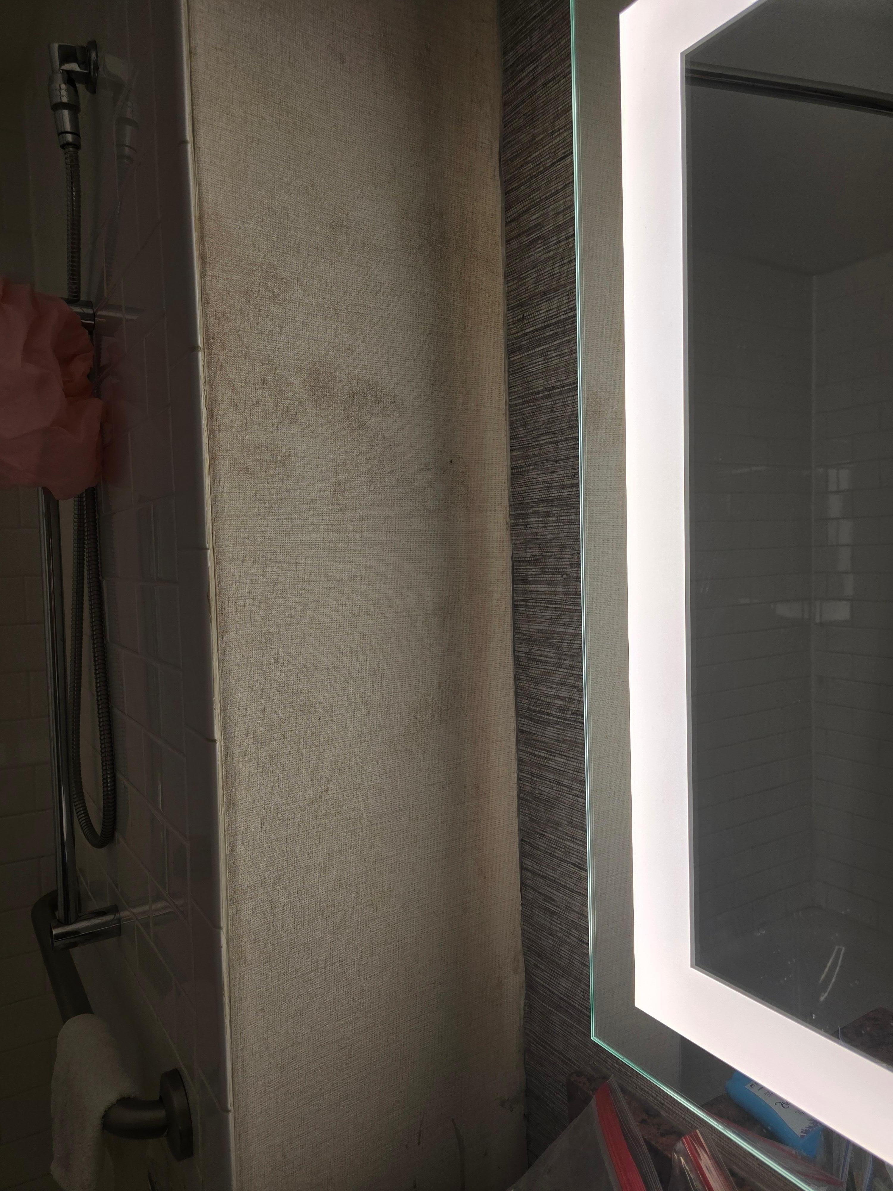 The wall near the mirror was dirty from the top of the wall to the bottom.