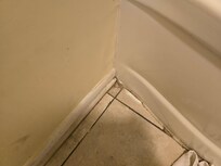 Black mold in the bathroom next to the tub