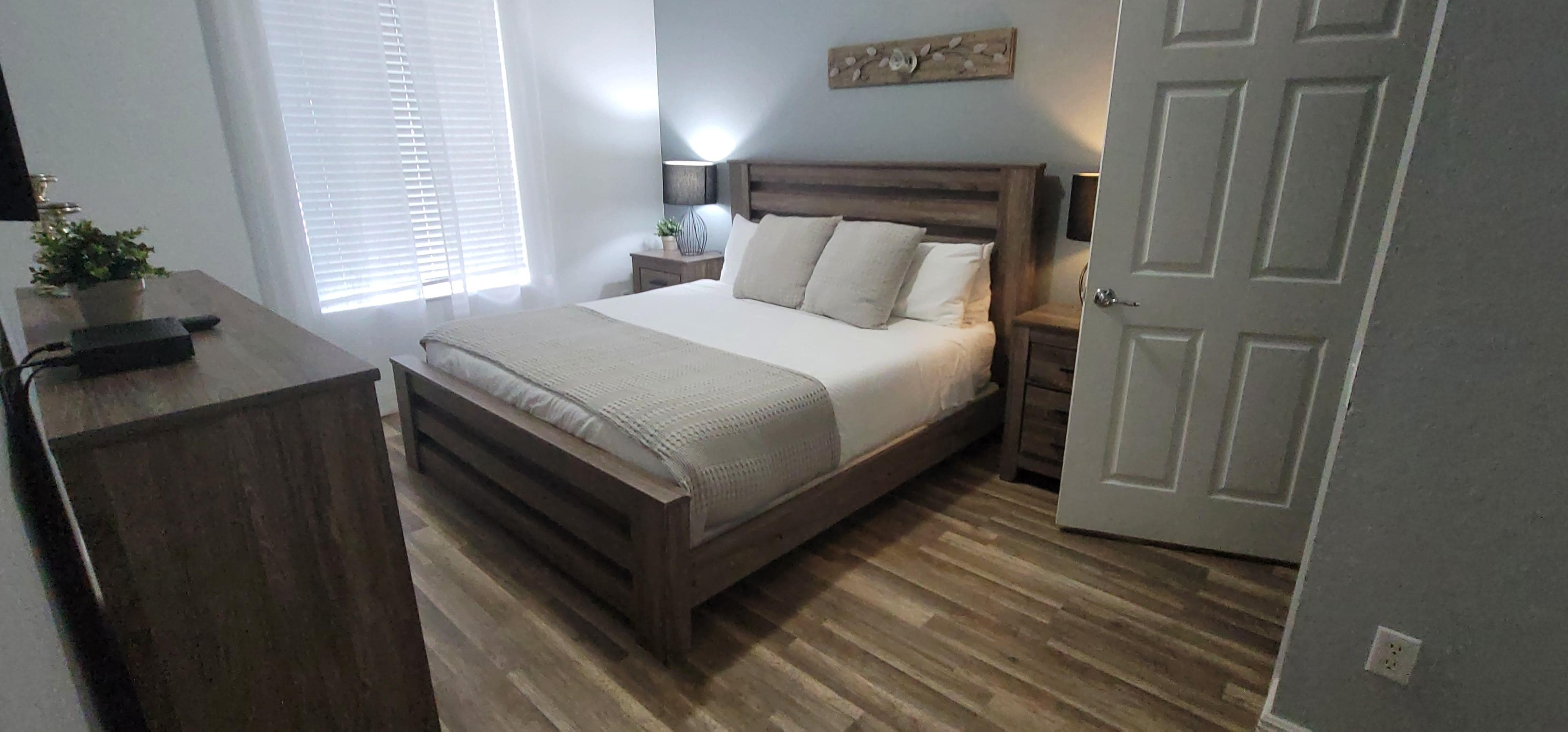 Room with King bed to the right of the dining table. 