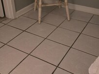 Imagine mopping your tile floor with salad oil. Add sand. See the grout next to the wall? White. And under the chair, which appears to never have been moved to clean in a long time.