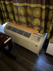 Board attached to air conditioner to keep the curtain back.