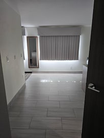 View walking in door. Bathroom & kitchen to right, beds to left