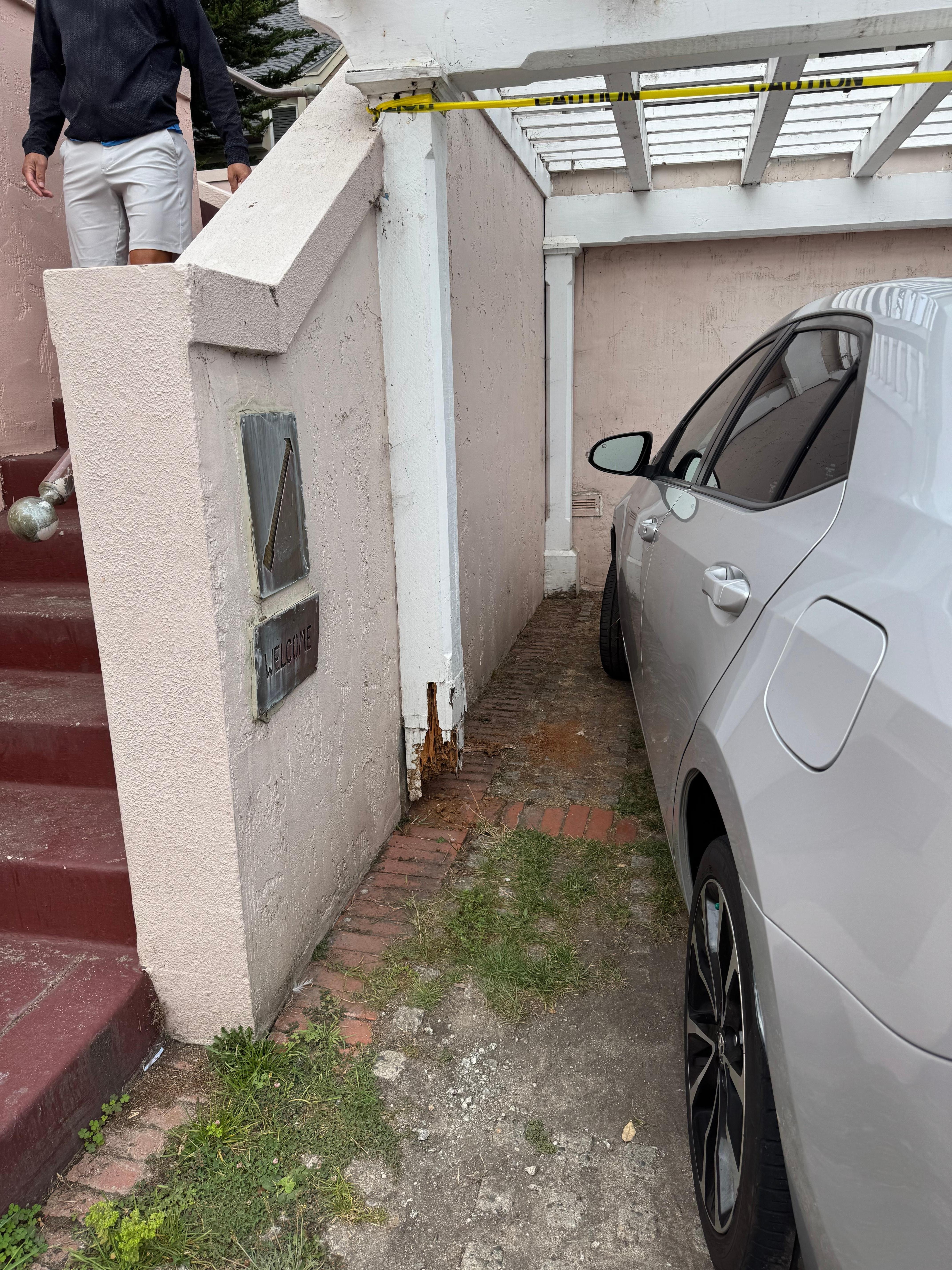Rotting wood holding up the trellis in the parking lot