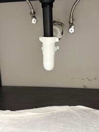 Under bathroom sink, water dripping.