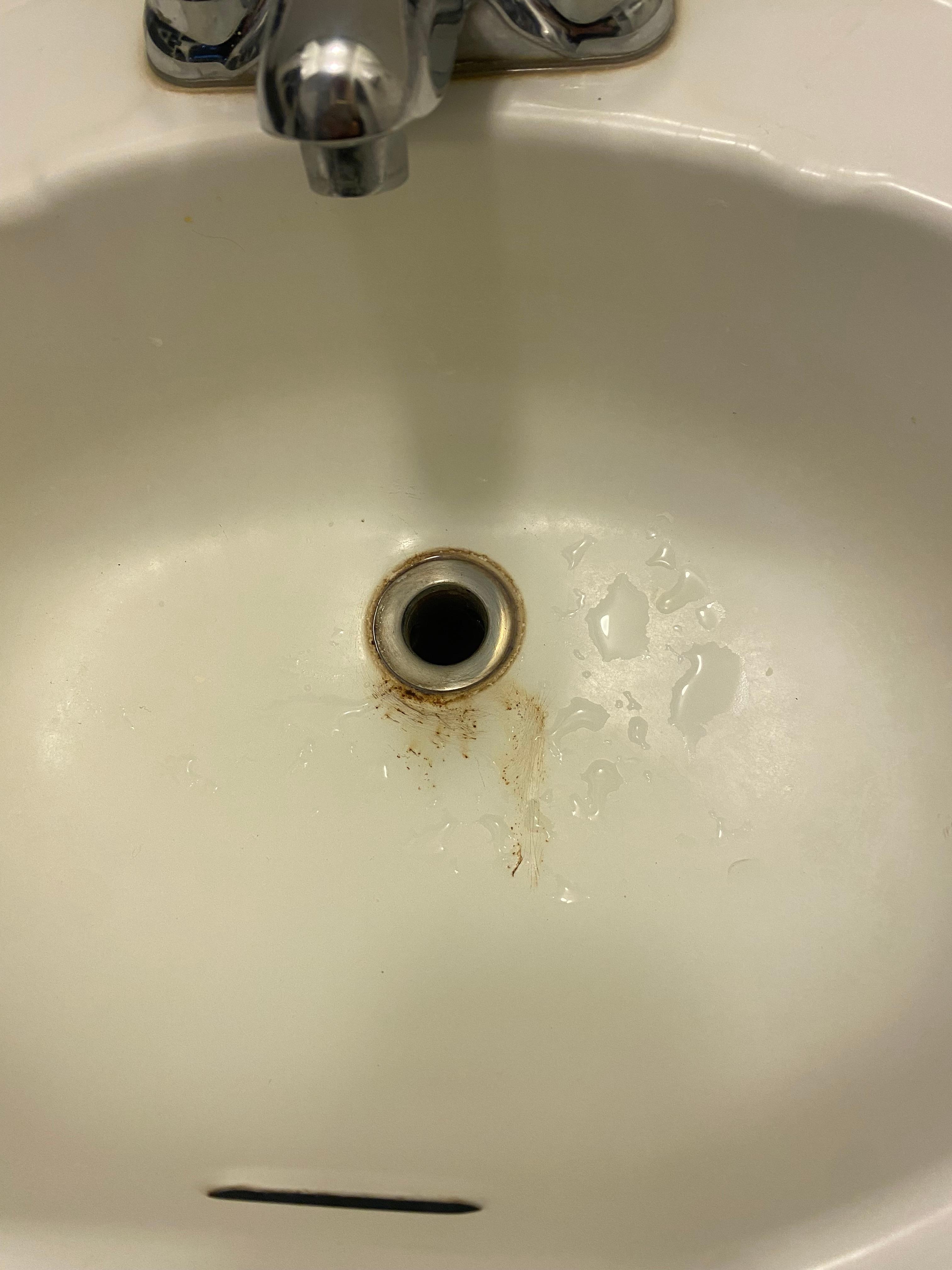 Stained, old sinks in all 3 rooms with missing drain stops.