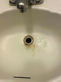 Stained, old sinks in all 3 rooms with missing drain stops.