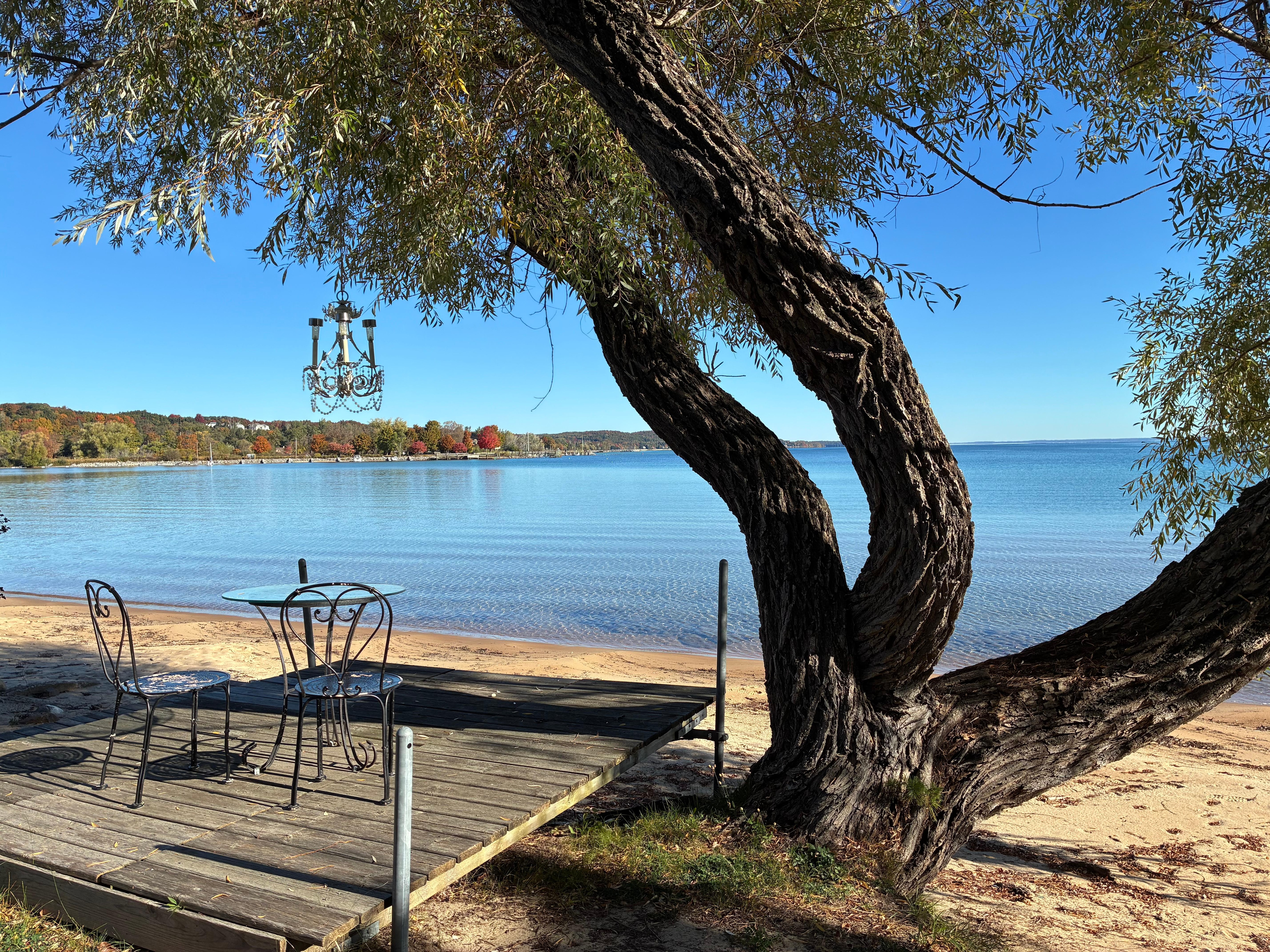 Another deck with table and chairs, and chandelier hanging from the tree. So cute!