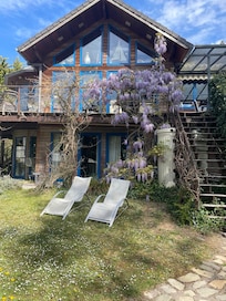 Holzhaus mit vielen Fenstern und großem Garten
