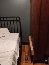 La separación de la cama y el mueble, no cabe una persona para caminar por ahí.