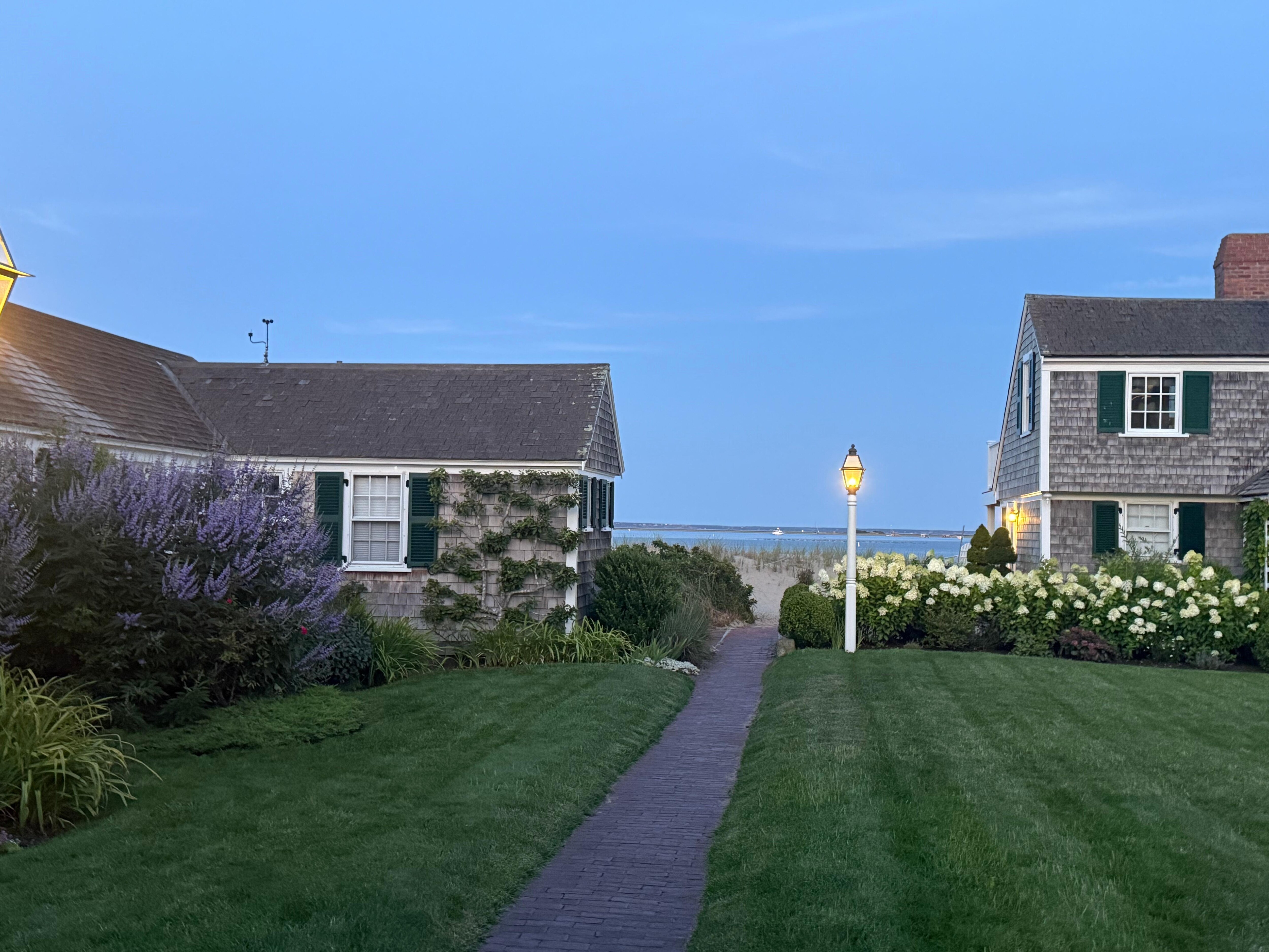 Wood shingled cottage faces a beautifully landscaped courtyard.