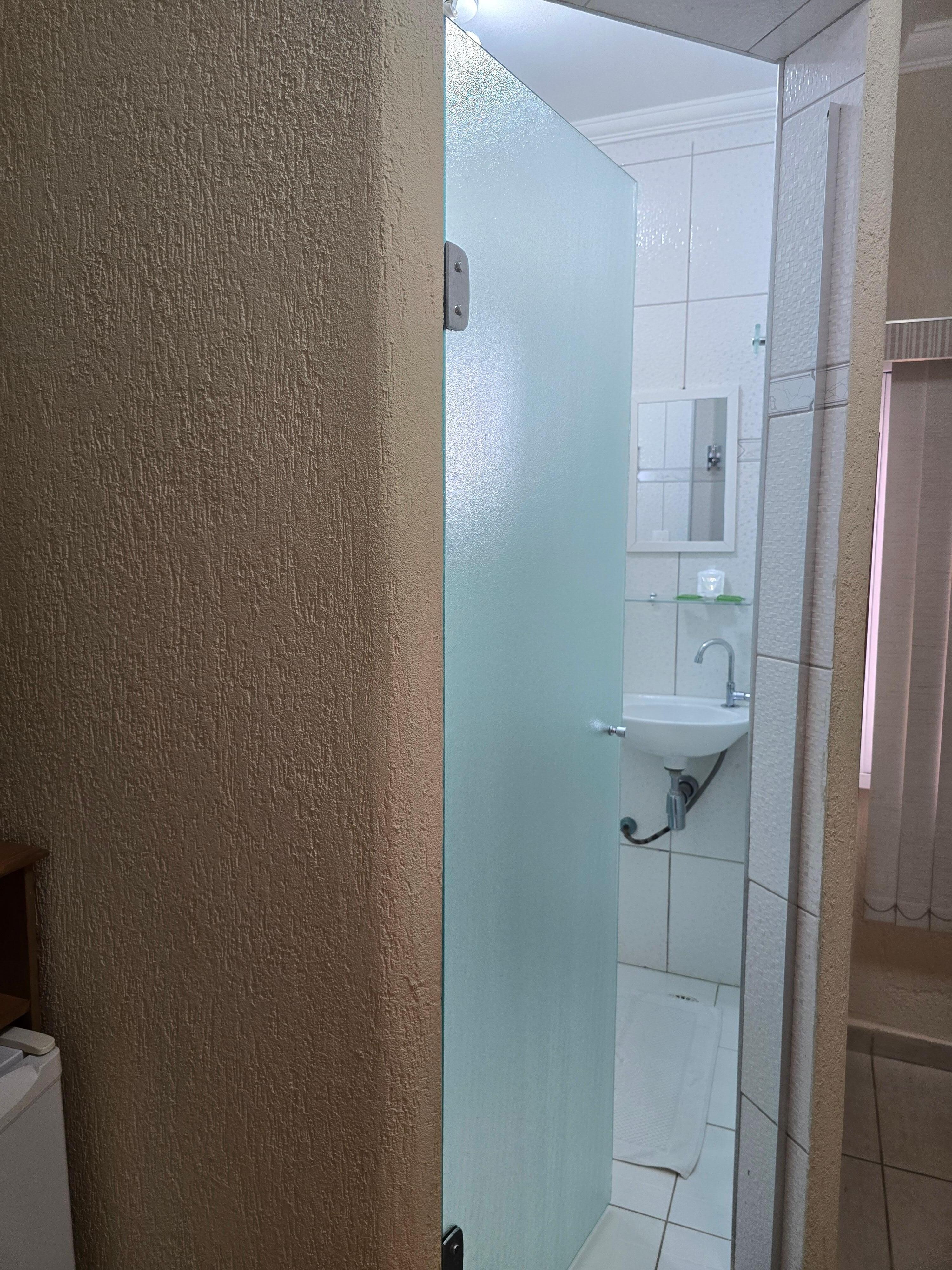 Porta do banheiro que deixa a claridade da manhã entrar assim que o dia nasce.