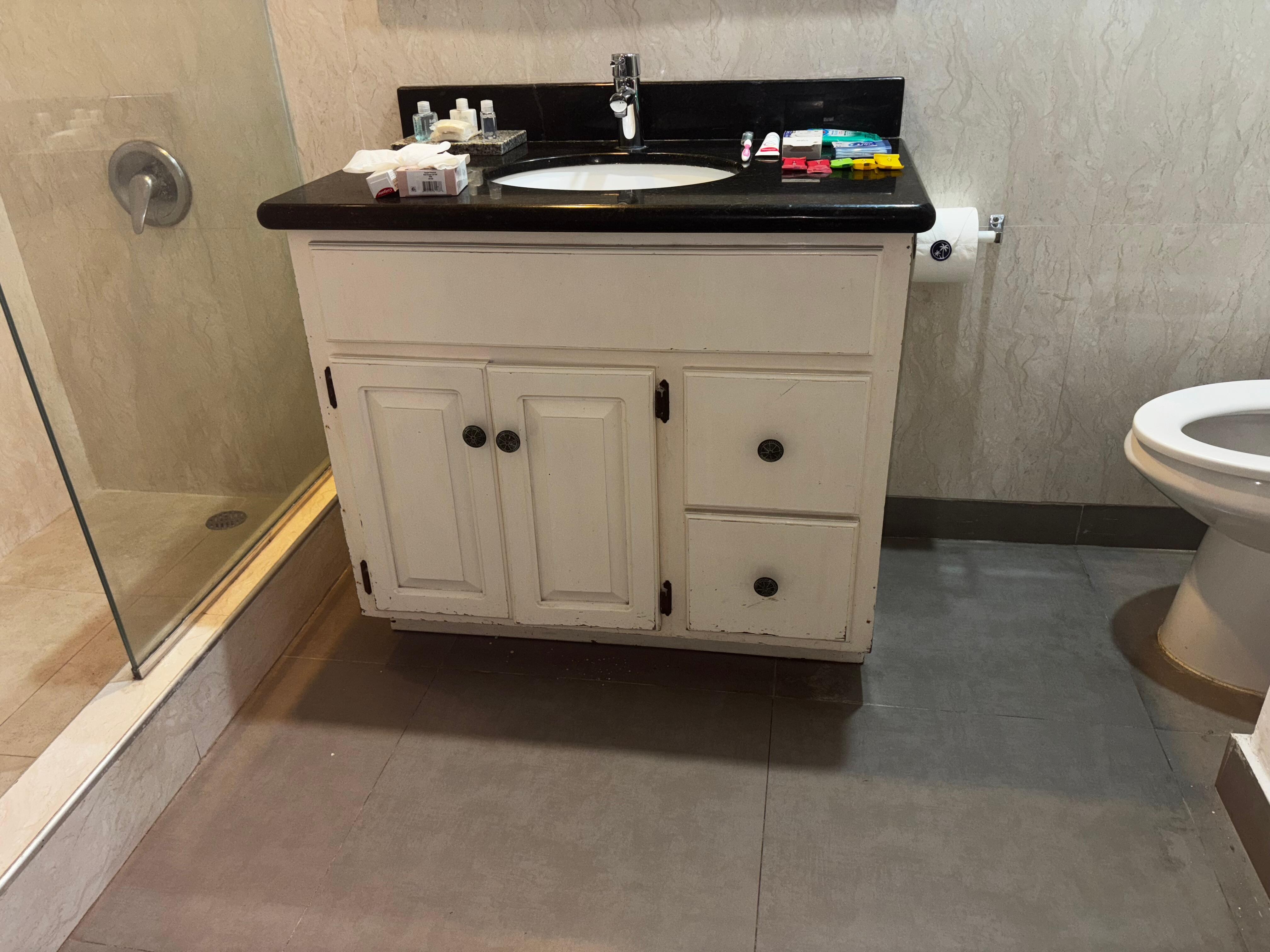 Outdated sink bathroom set up. I wish I could’ve provided a better picture as to showing you the big open area where there could’ve been a tub placed because it was so much space and it had a shelving area as if it was a storage area 