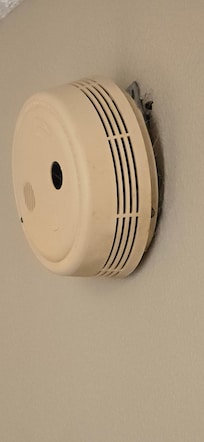 Fire alarm hanging off the wall