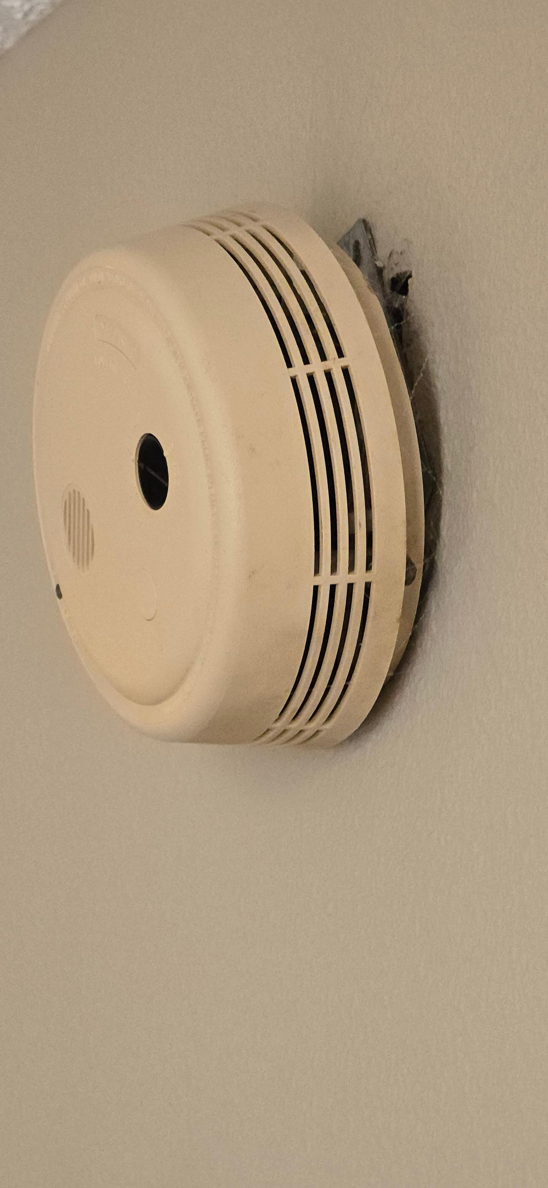Fire alarm hanging off the wall