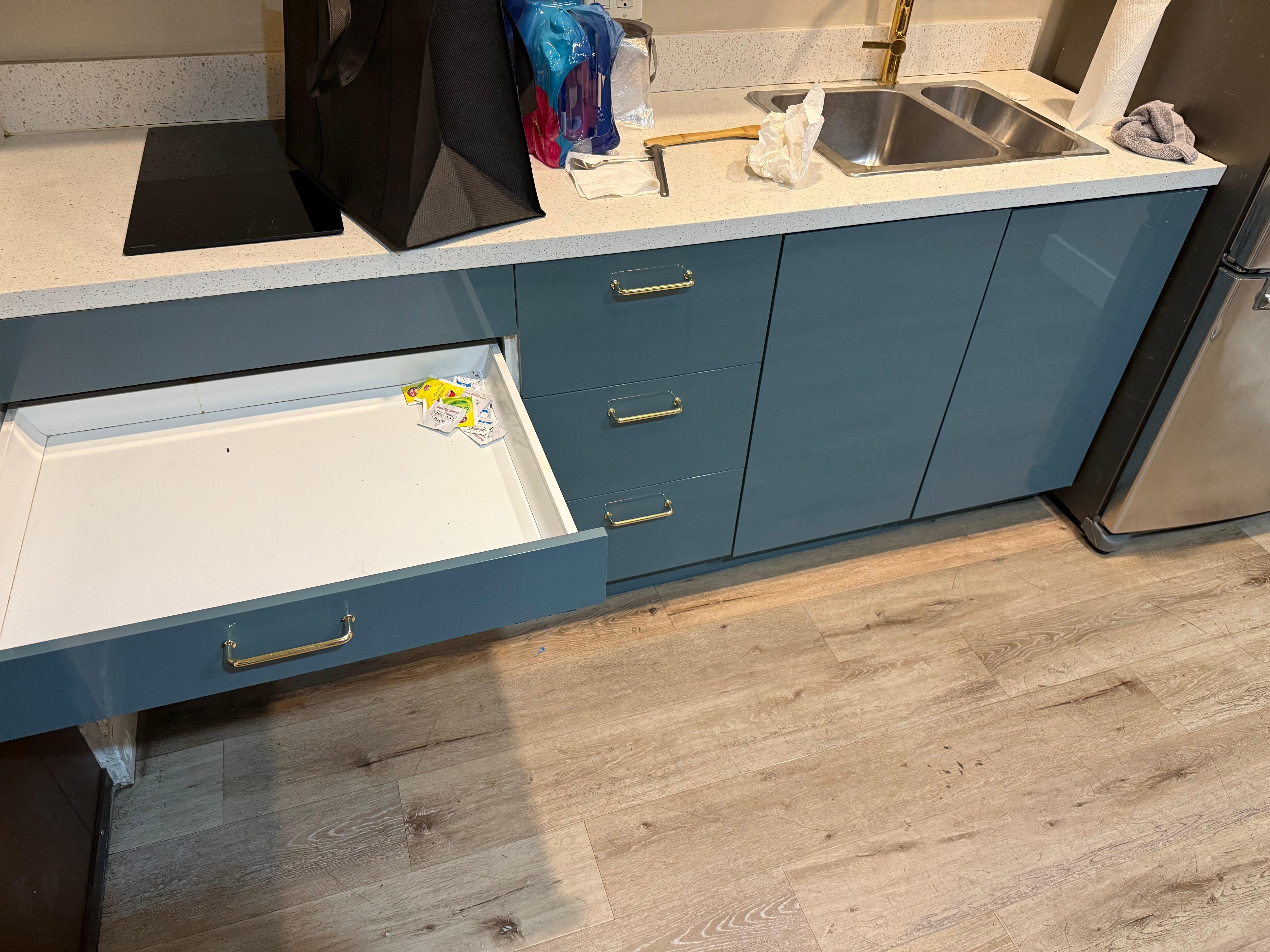 Drawer in the kitchen with discarded condiments packages and a roach.