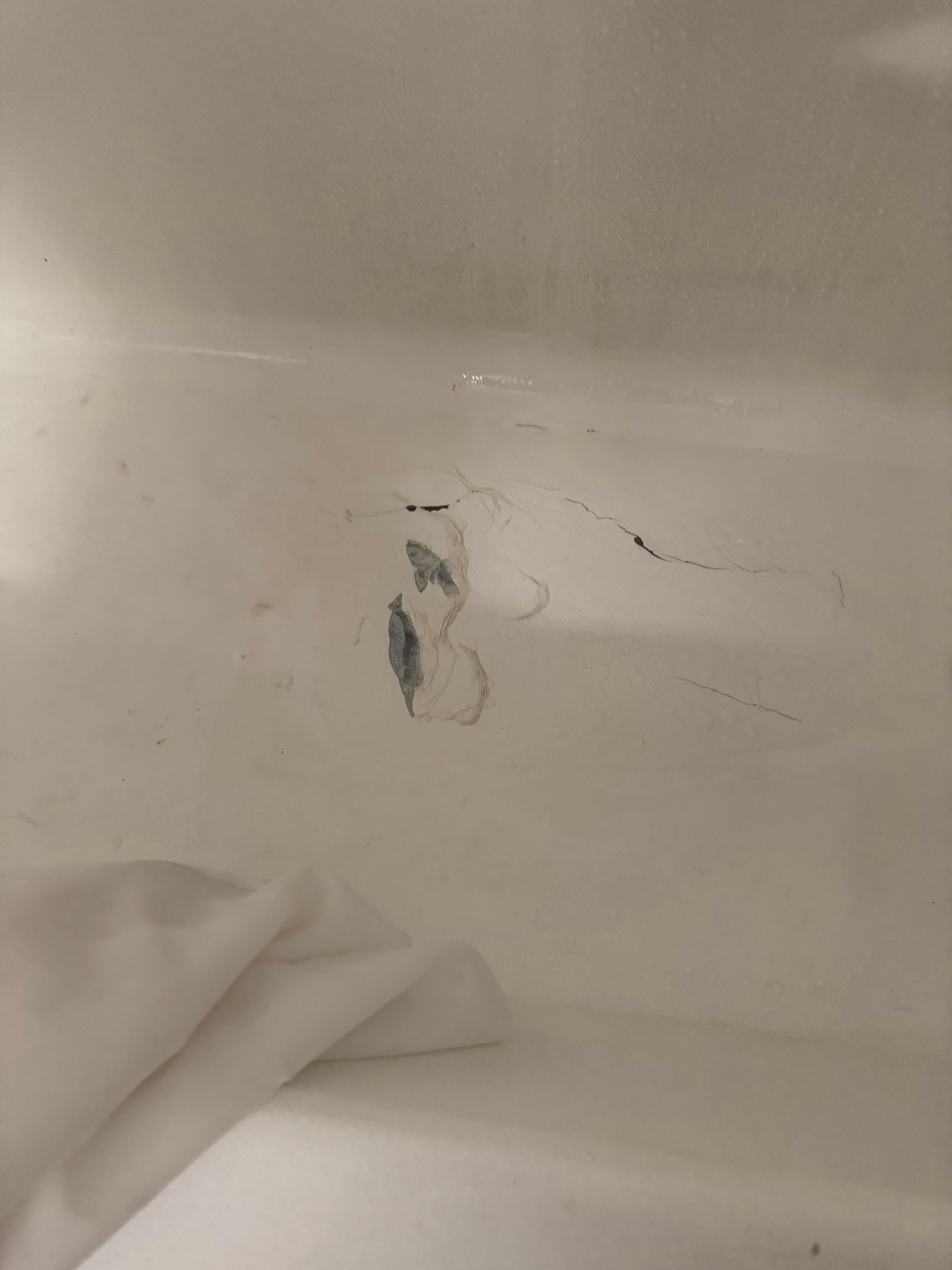 Hole in bottom of bathtub covered with duct tape and sealant
