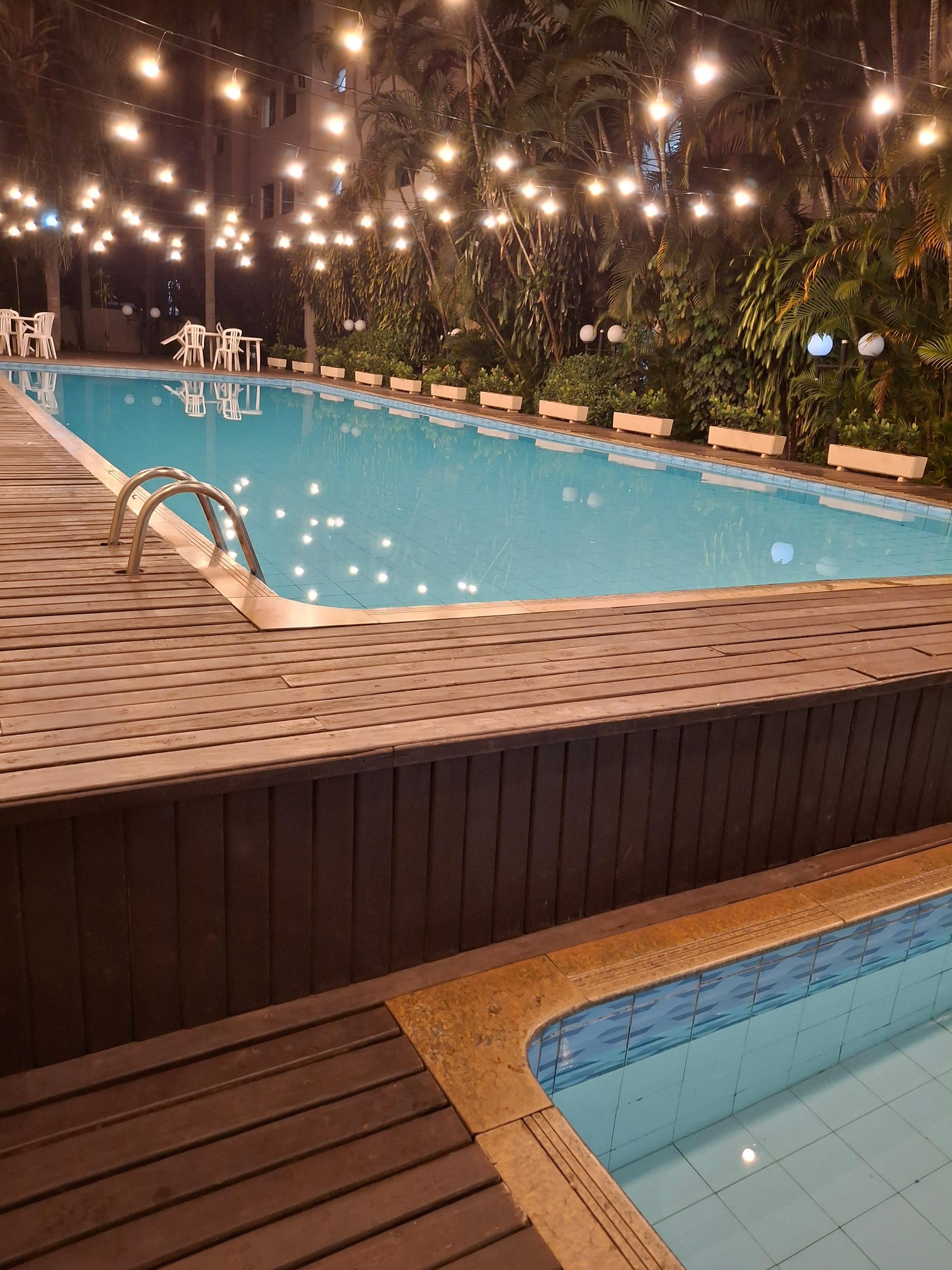 A piscina a noite é bem iluminada.