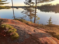 The house is on the rocky shore that can be traversed down to the water