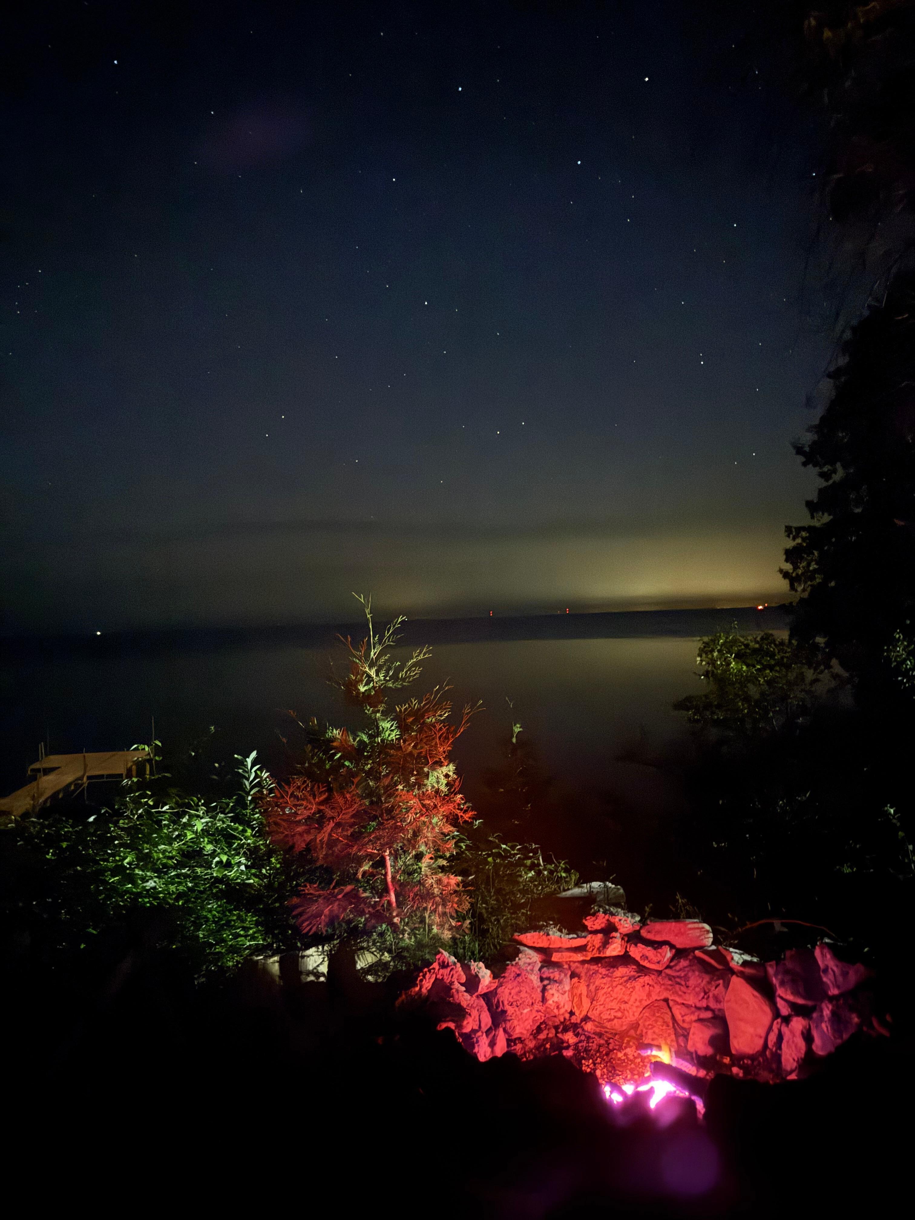 Picture of the view of the bay taken at night with the glow of the firepit. 