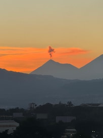 From the terrace overlooking the city skyline, I can see the bustling streets below and the distant mountains peeking over the horizon.