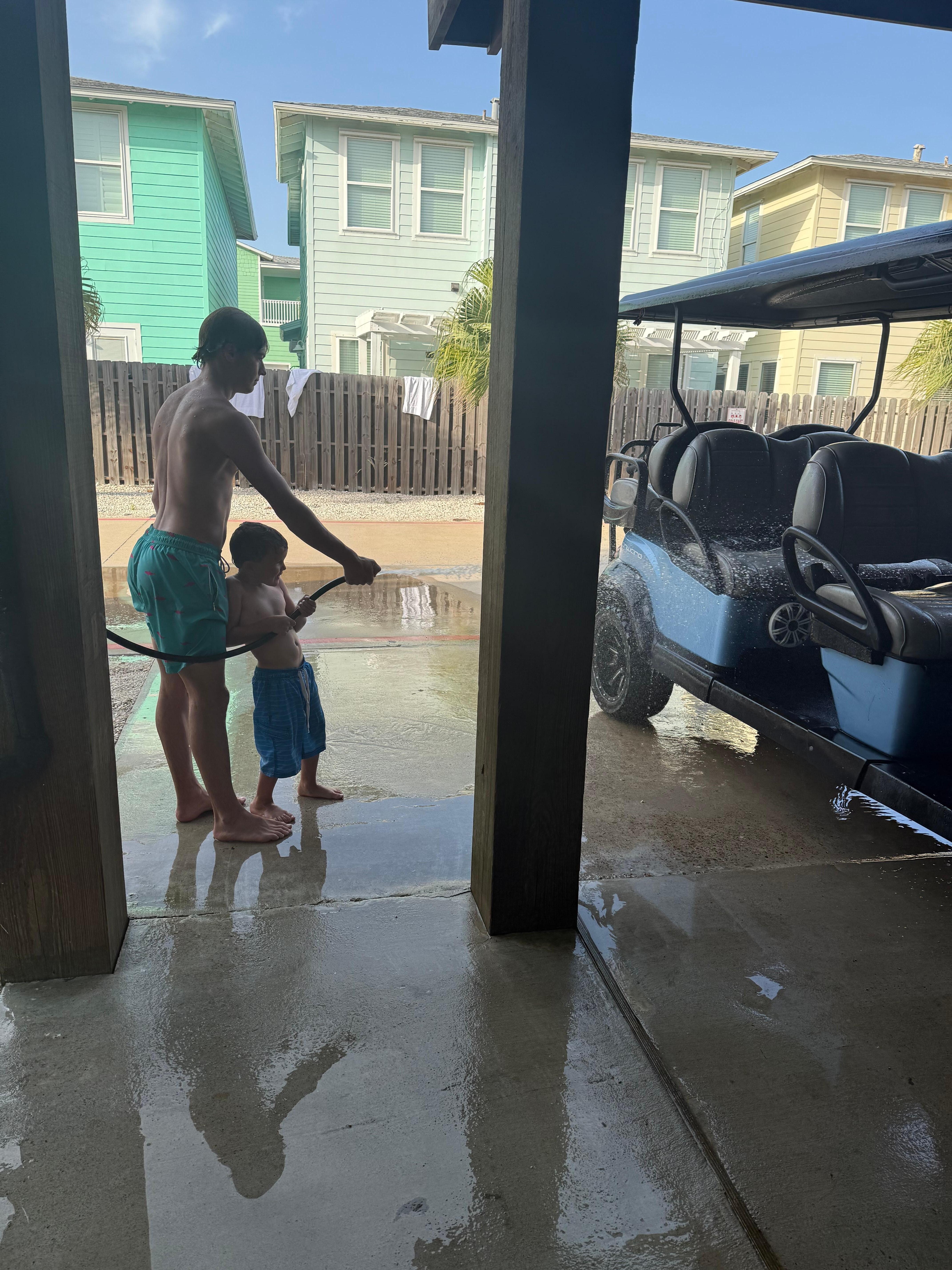 Washing the sand off the golf cart