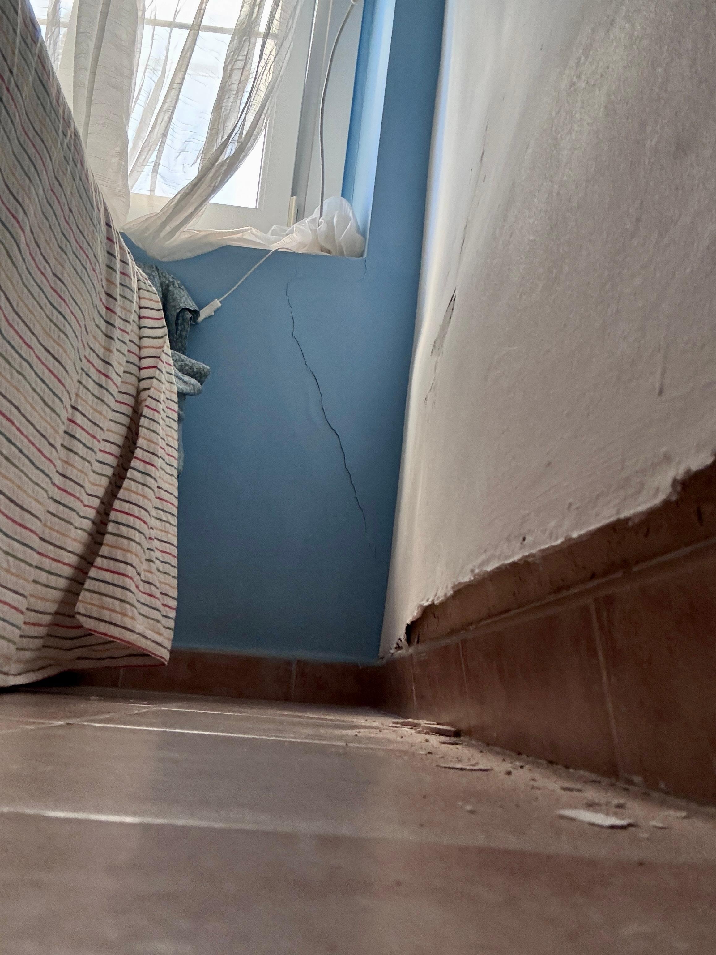 The bulging, cracked damp bedroom wall.