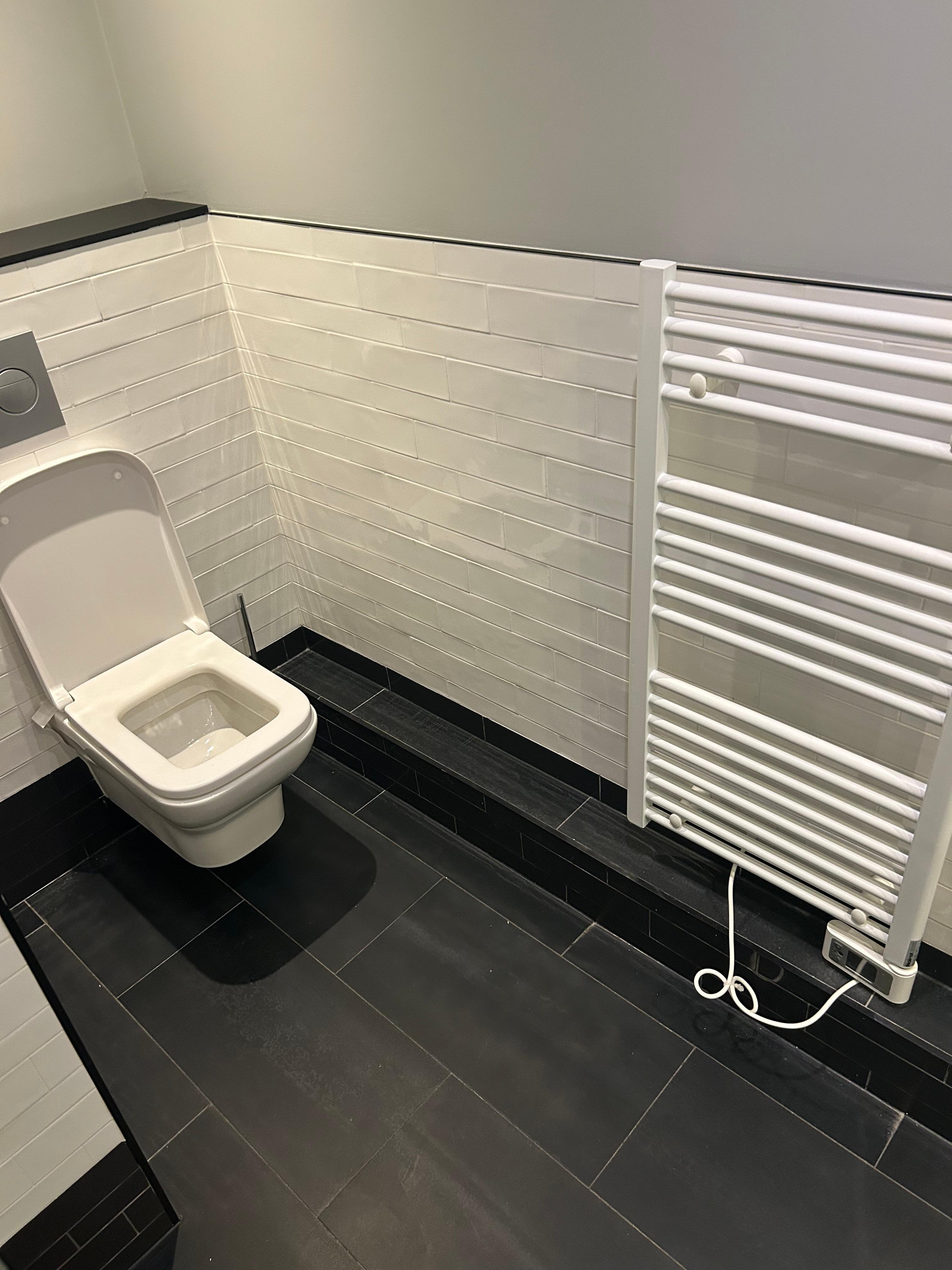 The bathroom is spacious and has a towel warmer