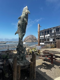 Dolphin Sculpture and Morro Rock on the Water