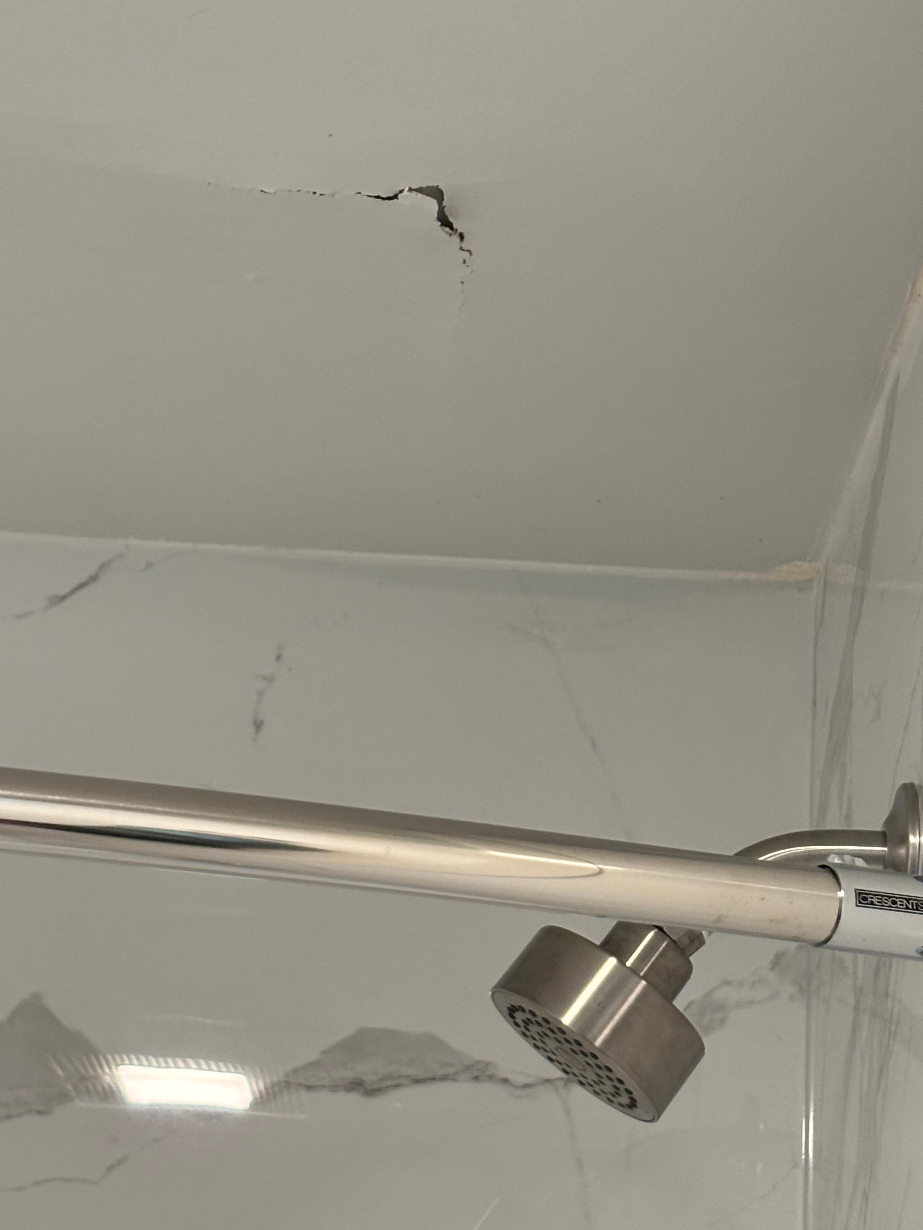 Hole ceiling above the shower head. Probably leak from the room above us. Which caused the damage 