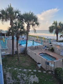 Pool area with jacuzzi, bar & grill, and sundeck. Easy beach access.