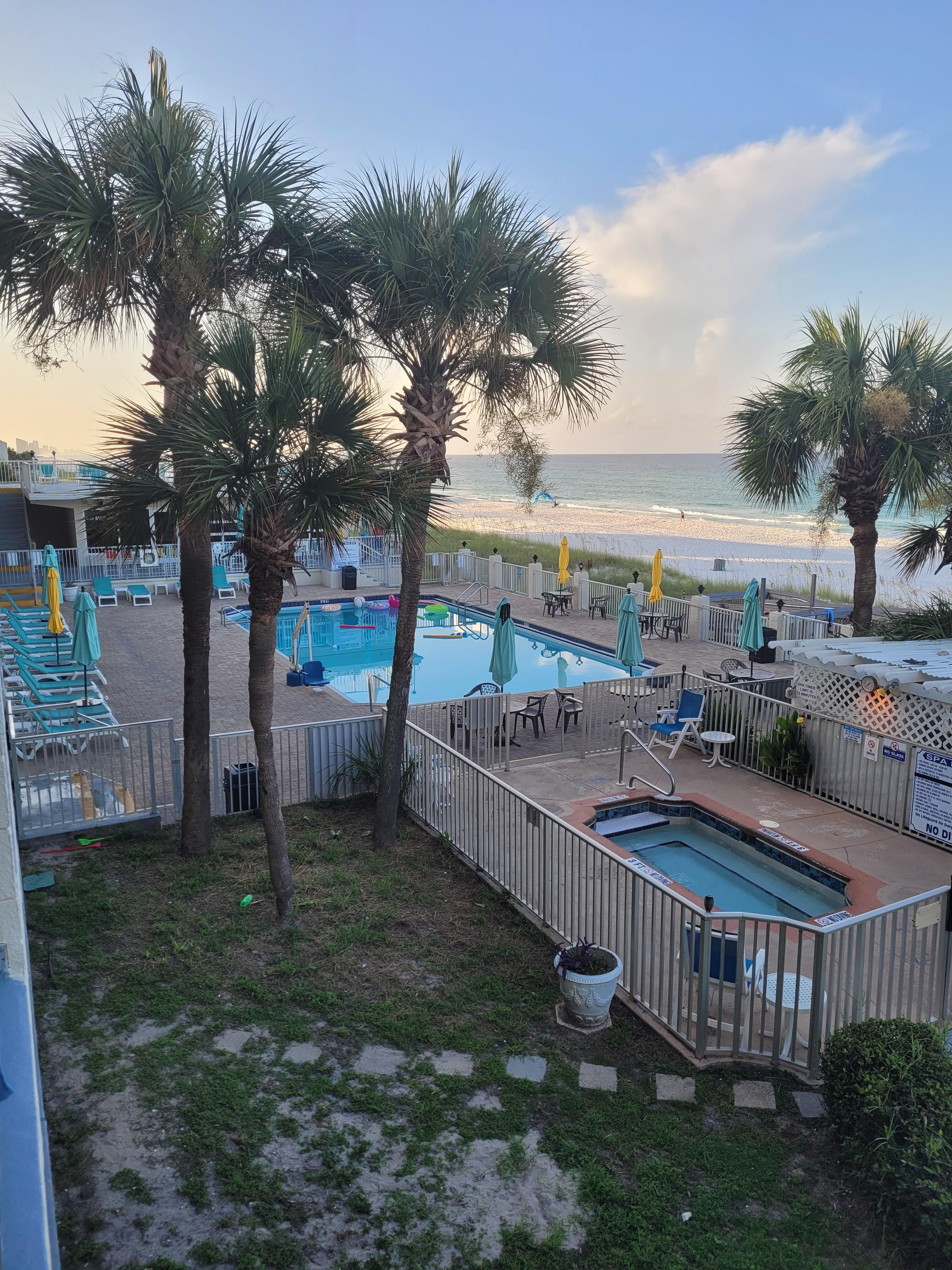 Pool area with jacuzzi, bar & grill, and sundeck. Easy beach access.