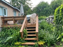 Lovely lush plantings around a well appointed little patio.