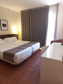 Spacious room with ample wardrobe space, mini bar and comfortable armchair.