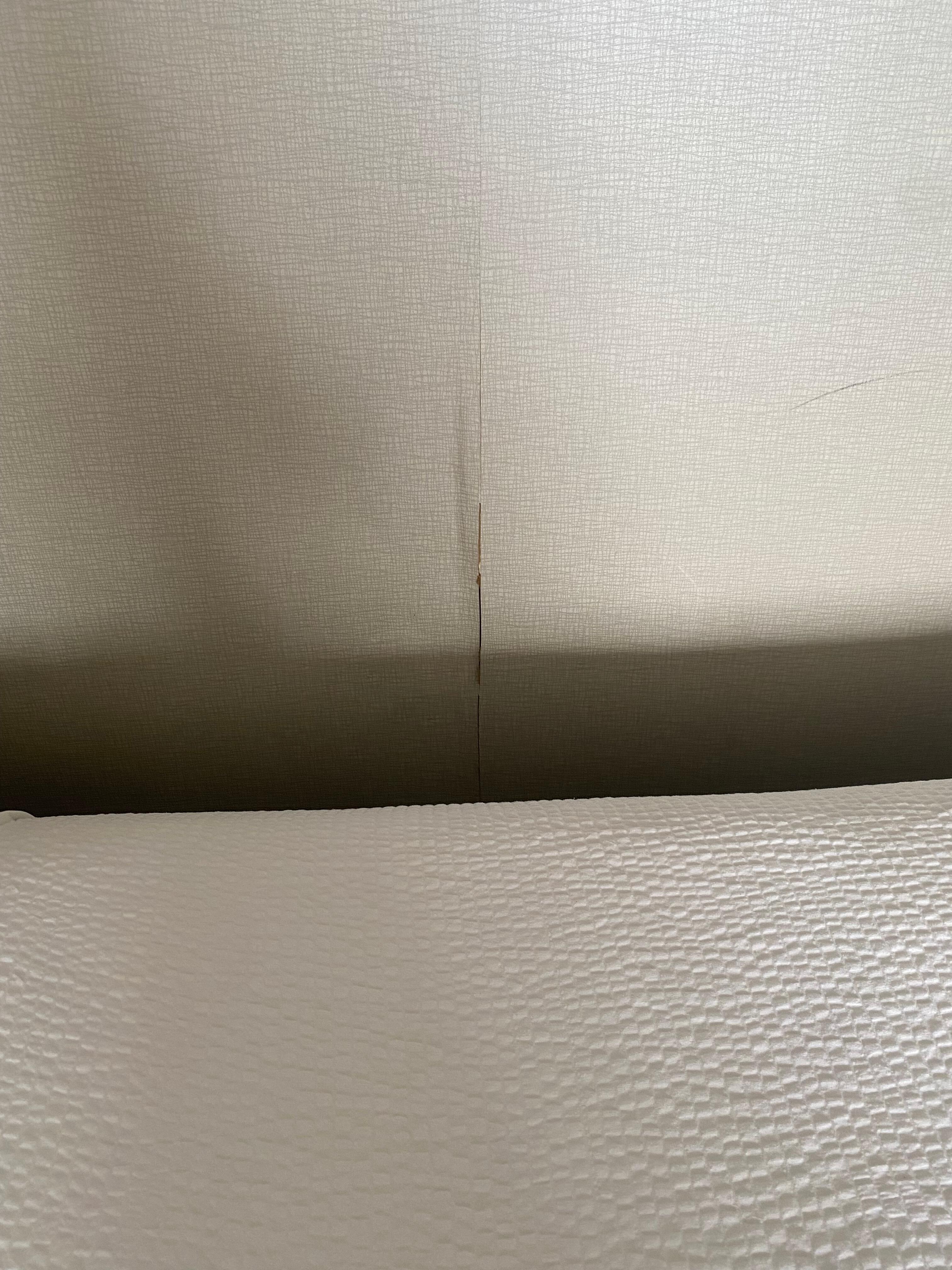 Cracked wall with wallpaper peeling off