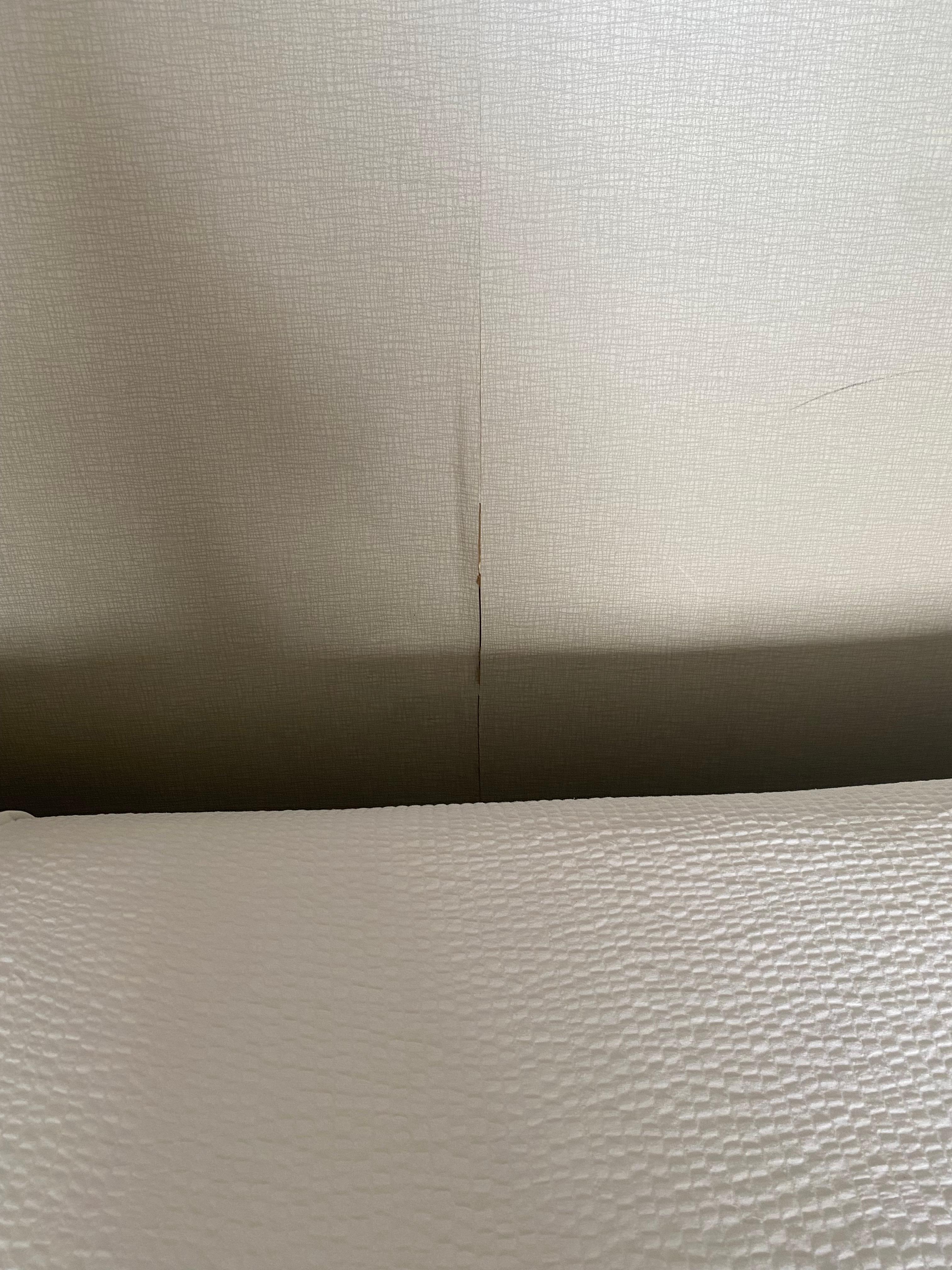Cracked wall with wallpaper peeling off