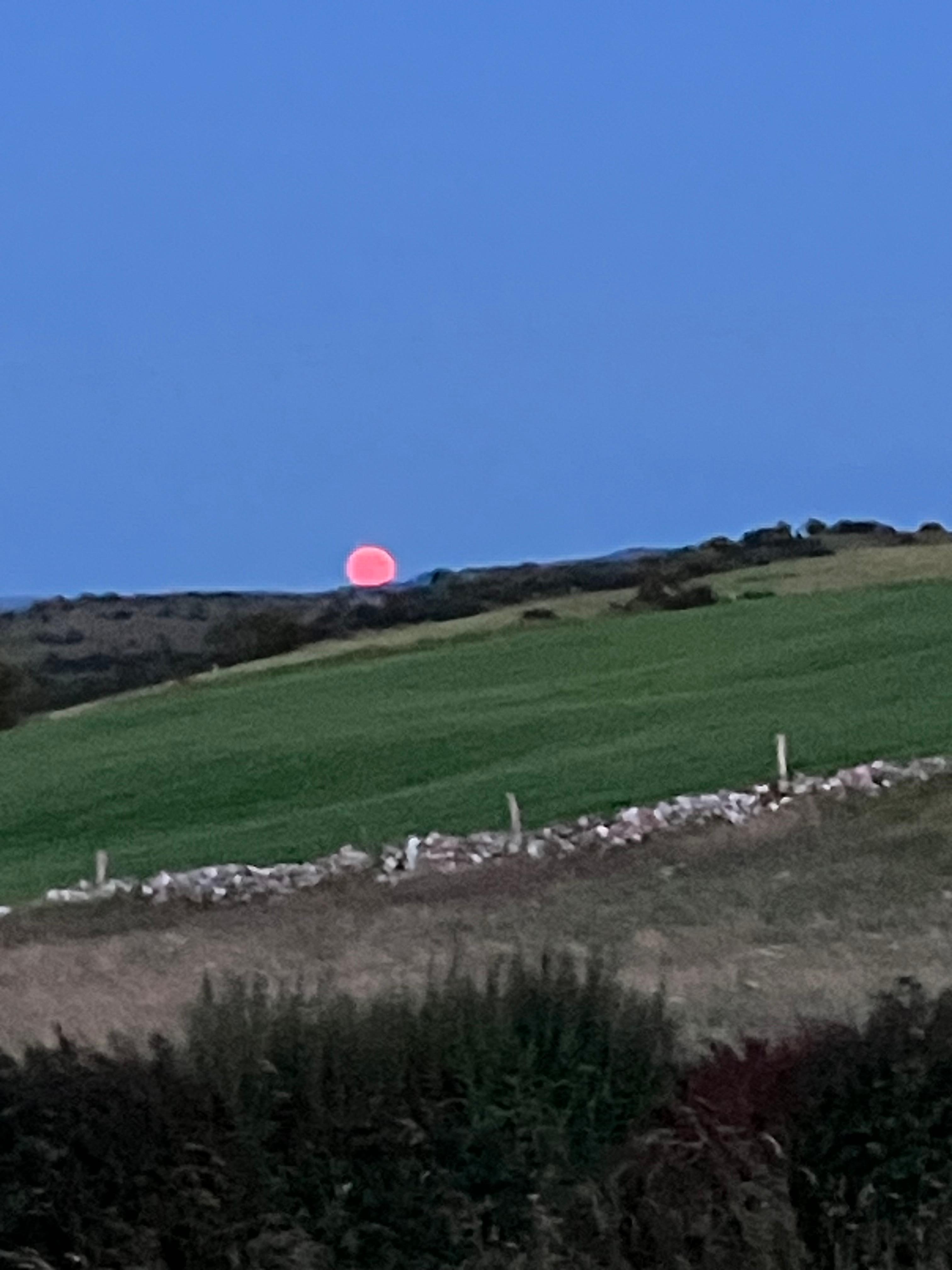 Full moon rising over the hill