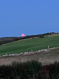 Full moon rising over the hill