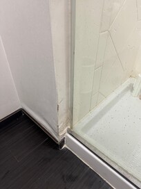 Drywall swelling because of a gap in the shower door and no ventilation fan in the bathroom