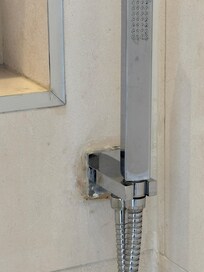 When you shower, water shoots out of the wall around the caulking at you