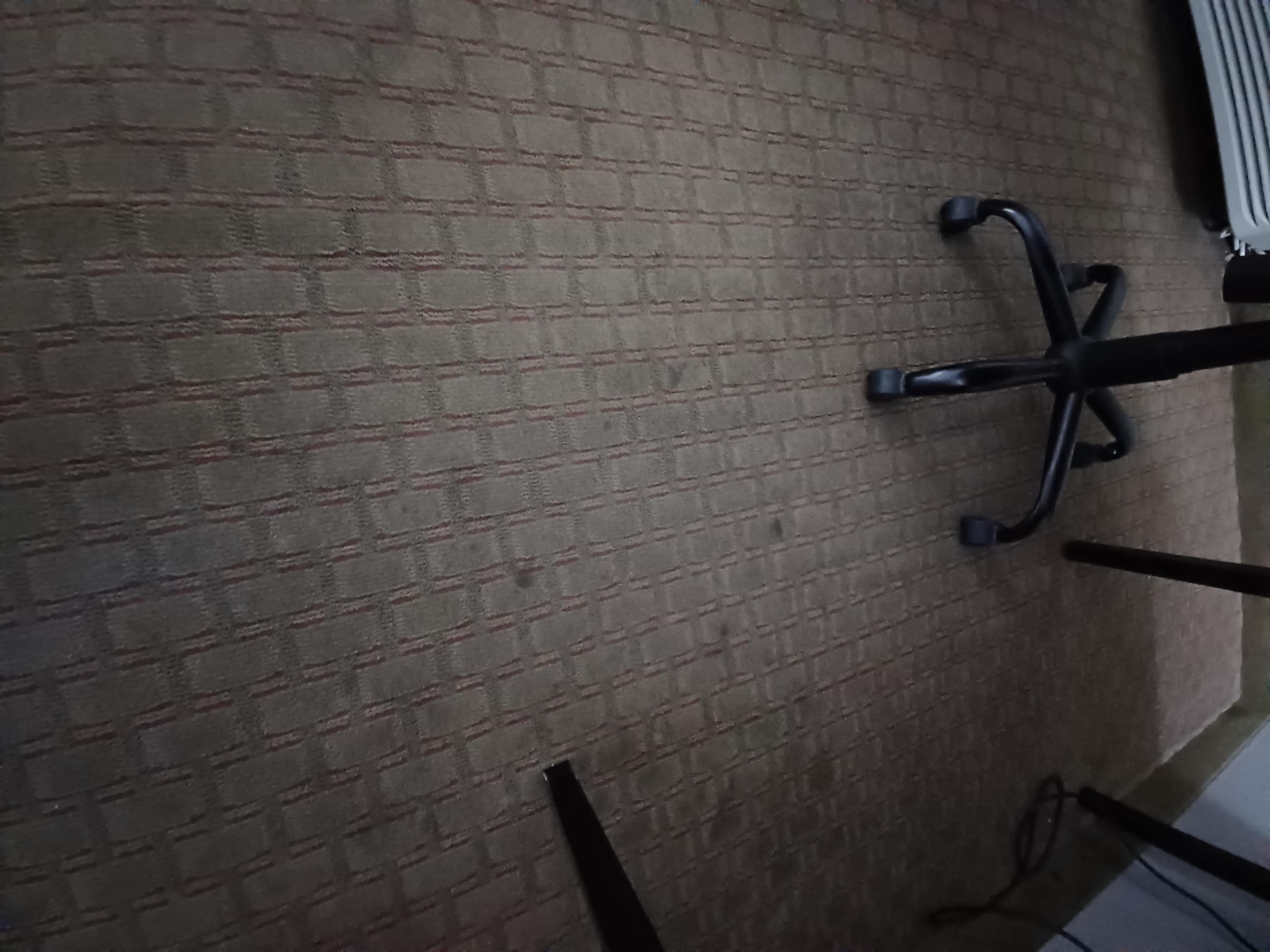 Stained carpet by the desk in room 