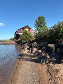 On the beach to the left of the inn