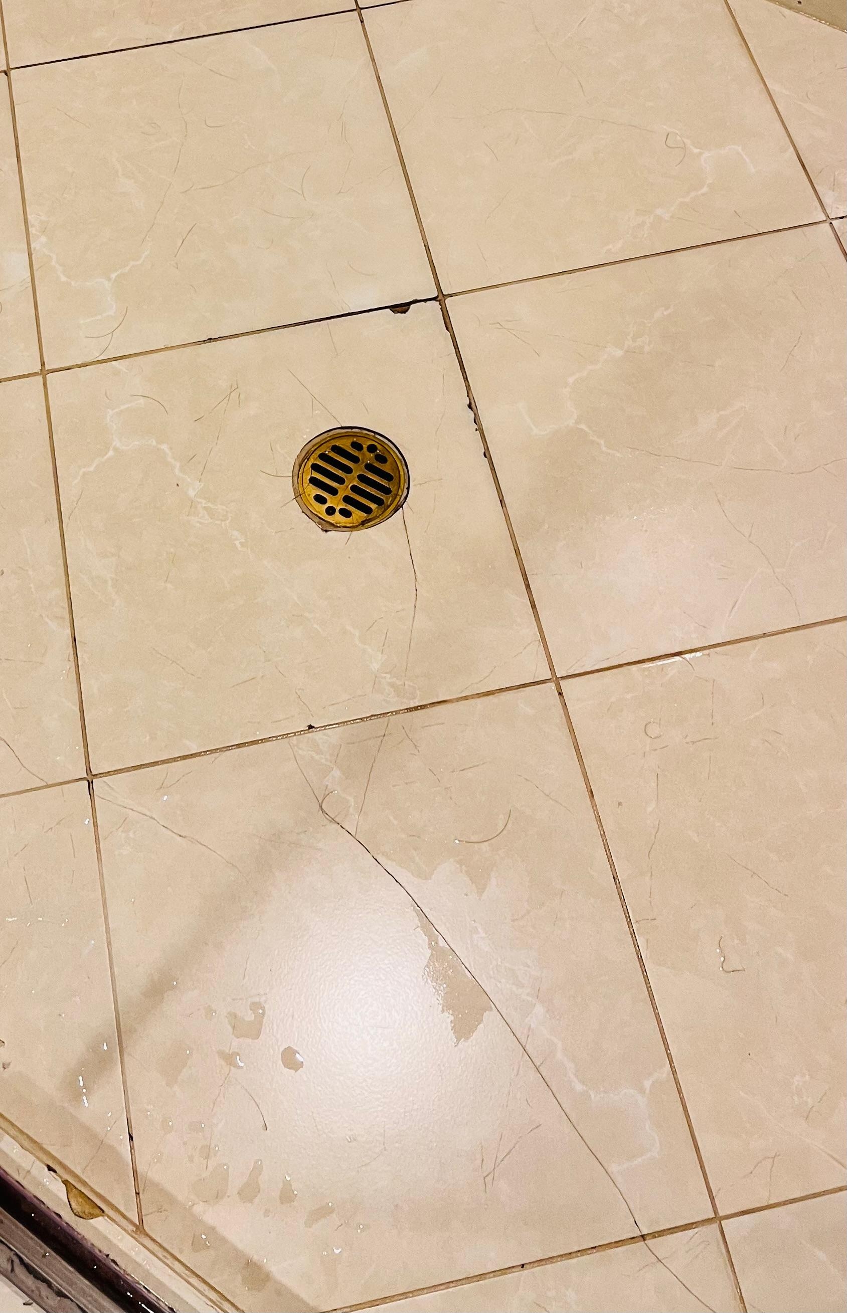 Piso agrietado y sucio en la ducha