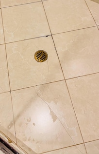 Piso agrietado y sucio en la ducha