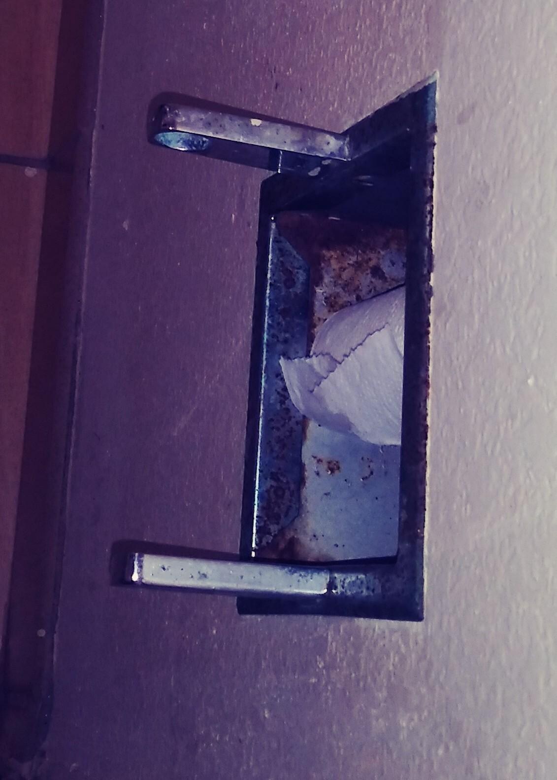 rusty toilet paper dispenser missing part to hold paper roll