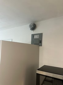 Exterior electric/gas meter and panel in interior of unit.