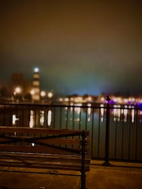 Light house, Mai Roma and police station visible with benches lining the walkway