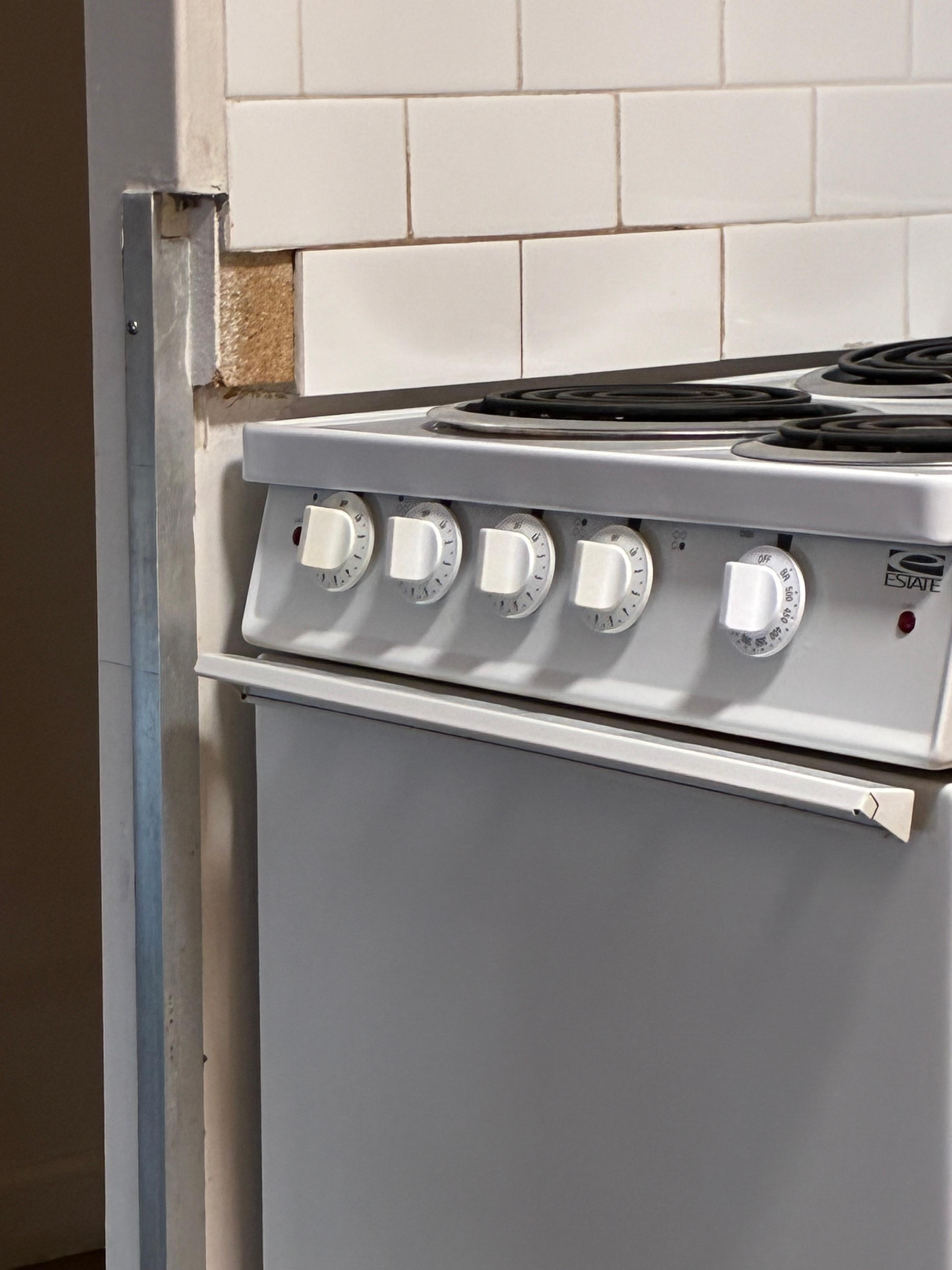 Tile missing on wall in kitchen.