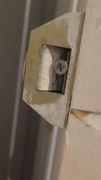 Screws shoved in door hinges. Unable to lock our room.